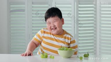 <strong>快乐</strong>的小胖男孩吃葡萄